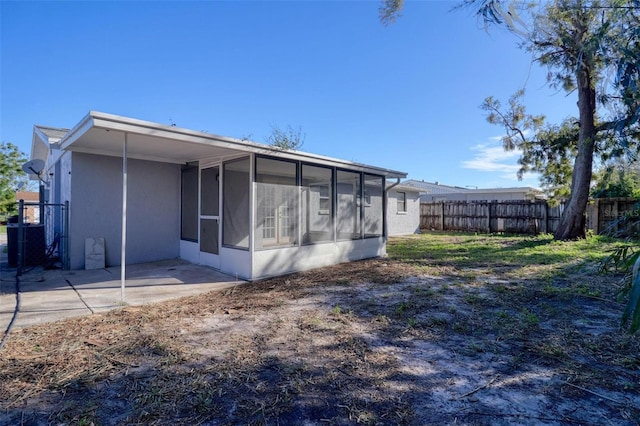 back of property with a sunroom and a patio area