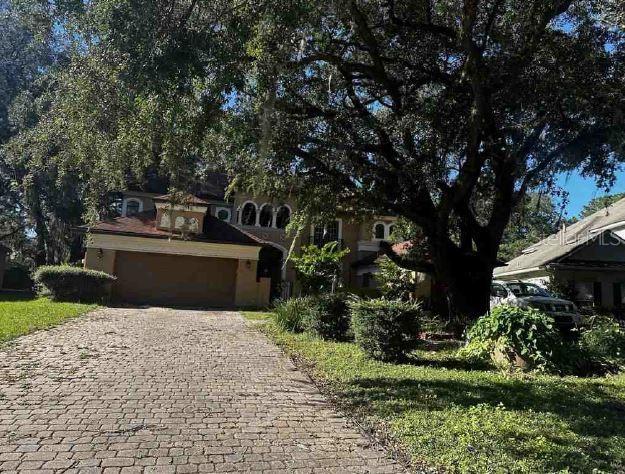 view of property hidden behind natural elements featuring a garage