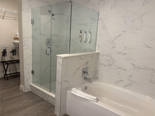 14501 Grove Resort Ave Unit 2608, Winter Garden, FL 34787 - full bathroom featuring a garden tub, a spacious closet, a shower stall, and wood finished floors