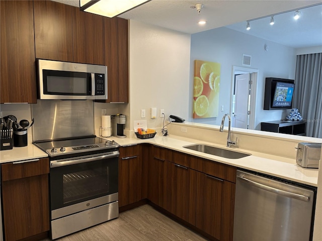 14501 Grove Resort Ave Unit 2608, Winter Garden, FL 34787 - kitchen with stainless steel appliances, a sink, modern cabinets, light countertops, and light wood finished floors