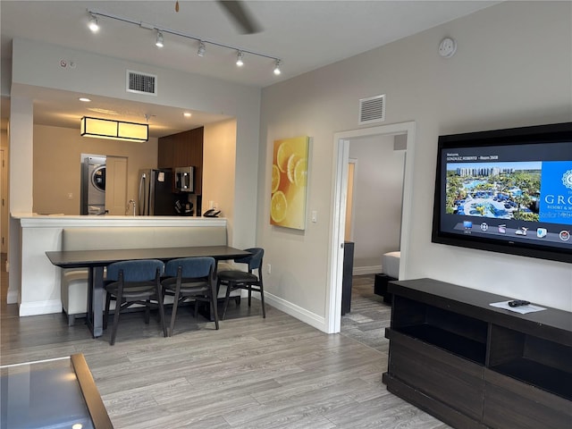 14501 Grove Resort Ave Unit 2608, Winter Garden, FL 34787 - dining space featuring stacked washer / drying machine, light wood finished floors, baseboards, and rail lighting