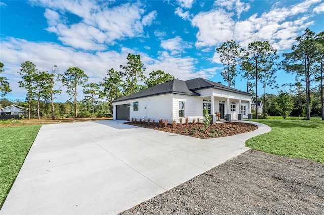 exterior space featuring covered porch, a garage, and a front lawn