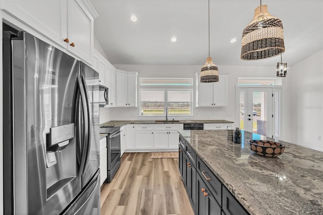 kitchen with lofted ceiling, black appliances, decorative light fixtures, white cabinets, and light hardwood / wood-style floors