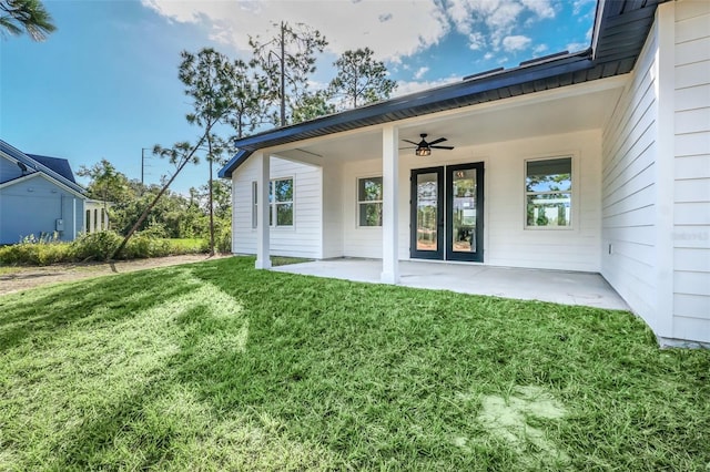 view of exterior entry with a yard, a patio, and ceiling fan