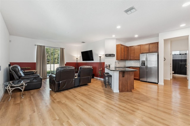 living room with light hardwood / wood-style floors and sink