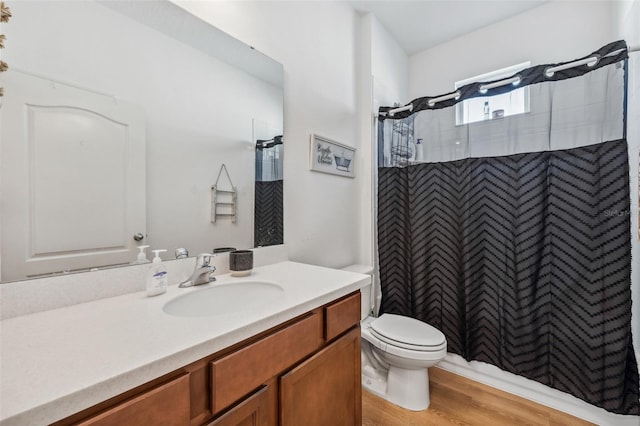 bathroom featuring hardwood / wood-style floors, vanity, toilet, and walk in shower