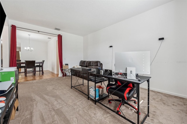 office with light colored carpet and a notable chandelier