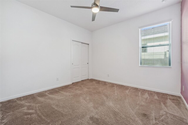 unfurnished room with carpet flooring and ceiling fan