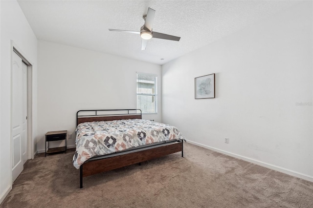 carpeted bedroom with ceiling fan, a textured ceiling, and a closet