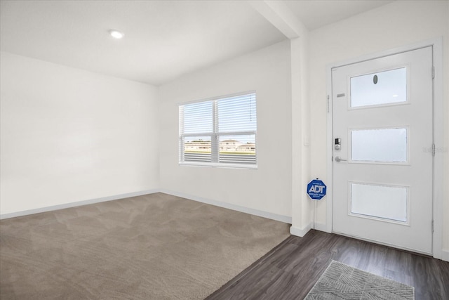 entrance foyer featuring vaulted ceiling and dark hardwood / wood-style floors