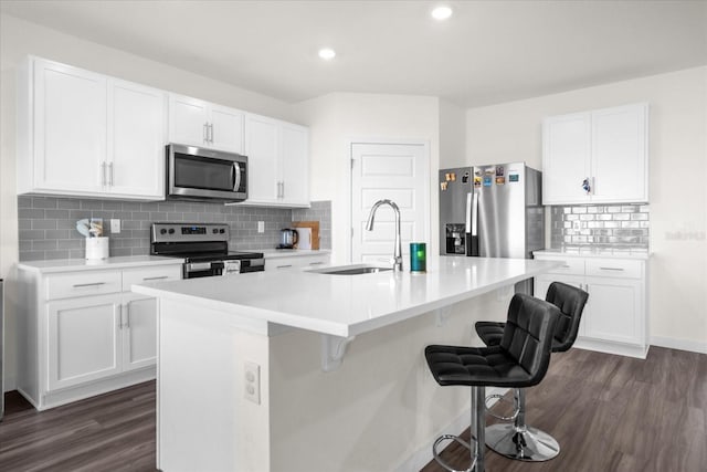 kitchen featuring sink, appliances with stainless steel finishes, white cabinetry, and an island with sink