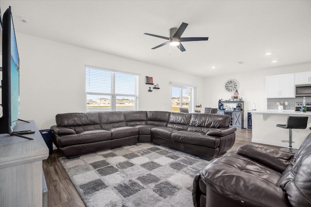 living room with ceiling fan and dark hardwood / wood-style flooring