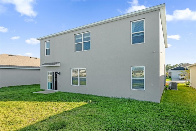 rear view of property with a yard and central air condition unit