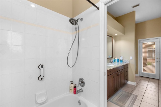 bathroom with vanity, tiled shower / bath combo, and tile patterned floors