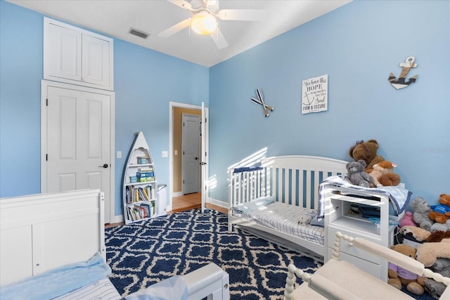 bedroom with a crib and ceiling fan