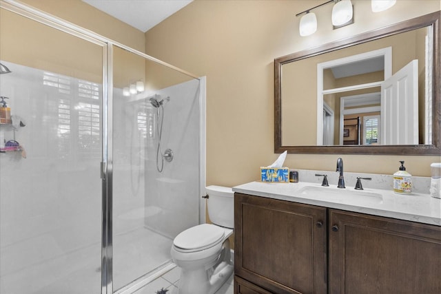 bathroom with toilet, vanity, tile patterned floors, and a shower with door