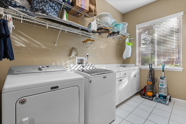 laundry room featuring cabinets, light tile patterned flooring, sink, and washing machine and dryer