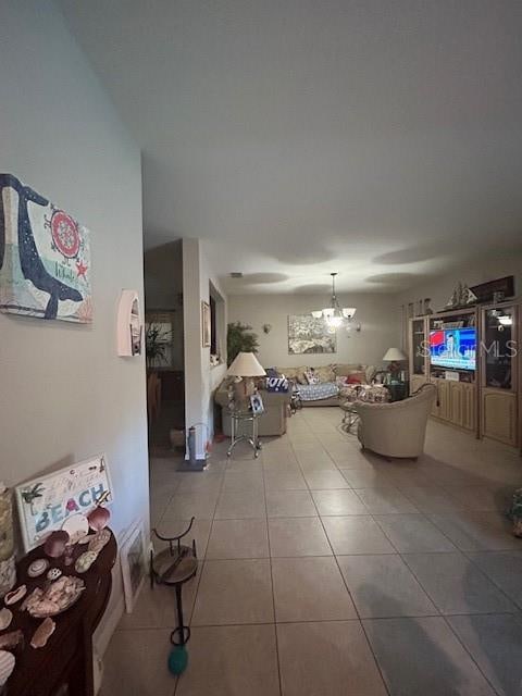 unfurnished living room with a chandelier and tile patterned floors