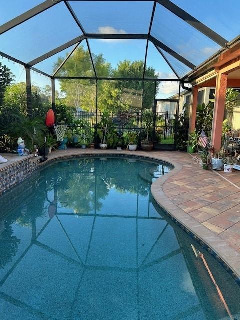 view of swimming pool featuring a lanai and a patio area