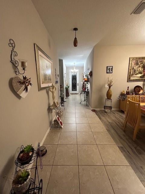 hallway with wood-type flooring and a chandelier