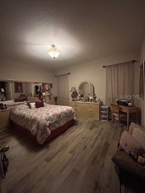 bedroom featuring dark hardwood / wood-style flooring and a textured ceiling