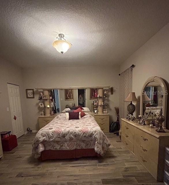 bedroom featuring a textured ceiling and hardwood / wood-style flooring