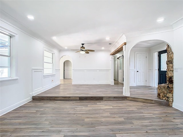 unfurnished living room featuring ceiling fan, crown molding, and dark hardwood / wood-style flooring