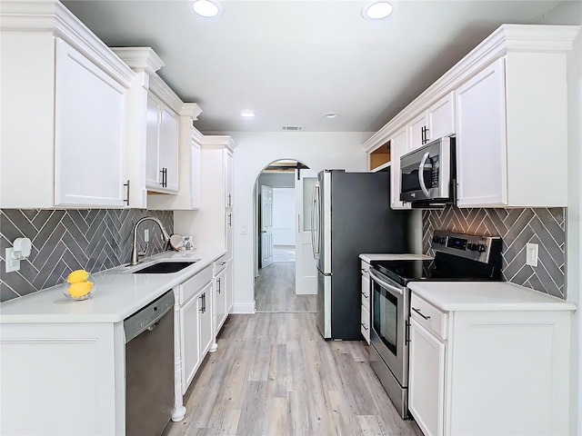 kitchen featuring sink, appliances with stainless steel finishes, light hardwood / wood-style flooring, and white cabinets