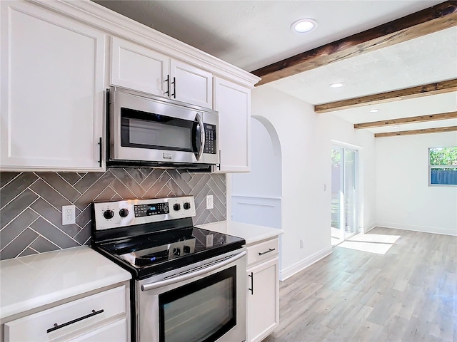 kitchen featuring backsplash, white cabinetry, stainless steel appliances, beamed ceiling, and light hardwood / wood-style flooring