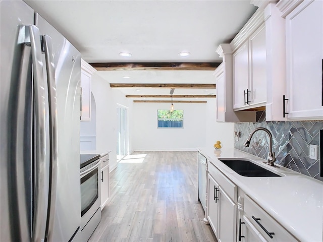 kitchen with appliances with stainless steel finishes, white cabinetry, beamed ceiling, pendant lighting, and sink