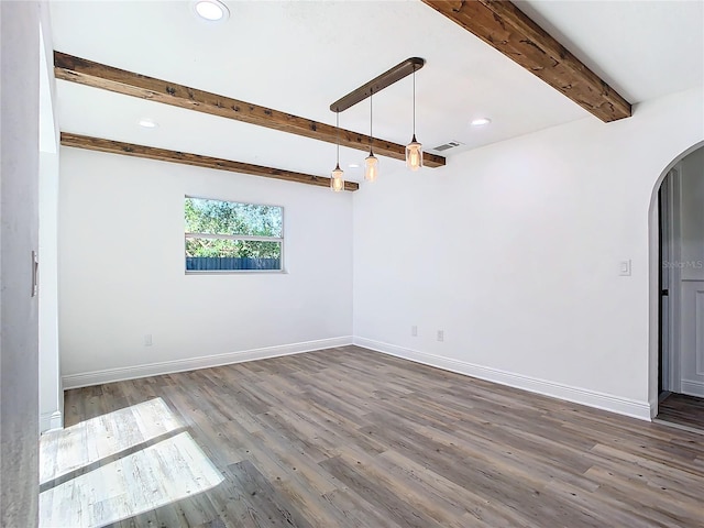 spare room with dark wood-type flooring and beam ceiling