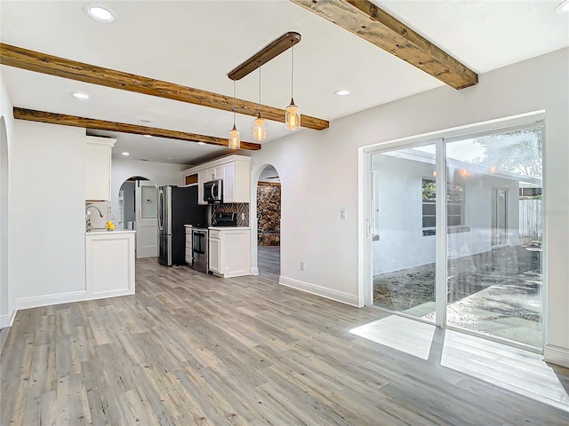 kitchen with beam ceiling, light hardwood / wood-style flooring, hanging light fixtures, stainless steel appliances, and white cabinetry