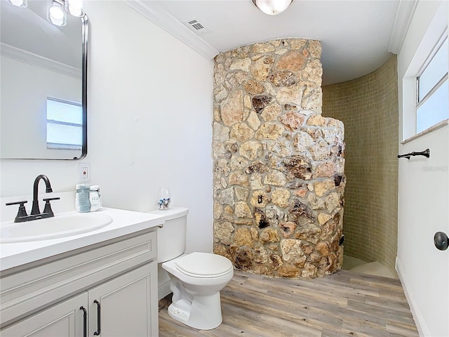 bathroom featuring vanity, toilet, crown molding, and hardwood / wood-style floors