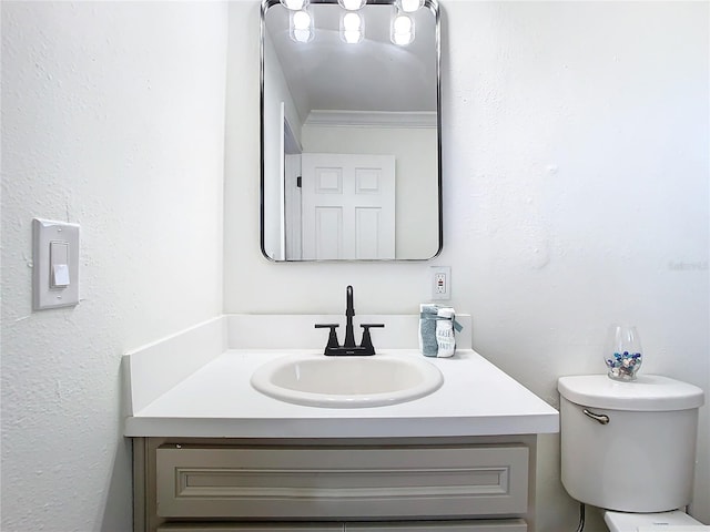 bathroom featuring vanity, toilet, and ornamental molding