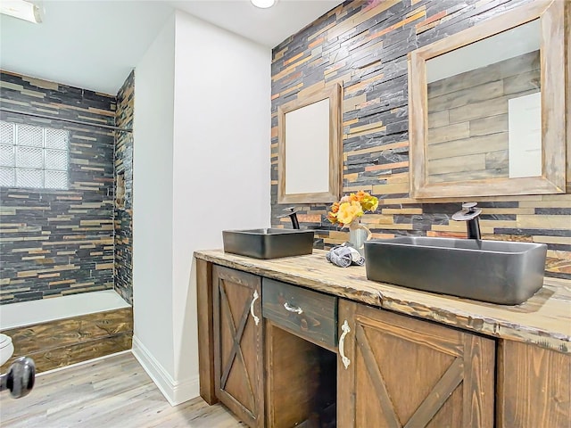 bathroom featuring vanity, hardwood / wood-style flooring, and backsplash