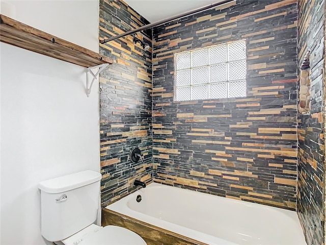 bathroom with tiled shower / bath combo and toilet