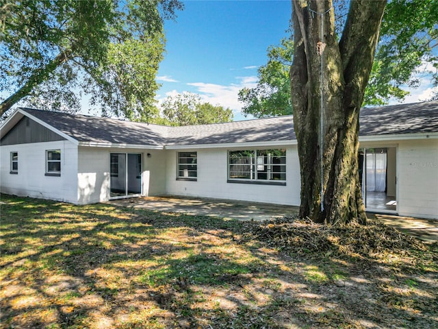 rear view of property featuring a patio and a lawn