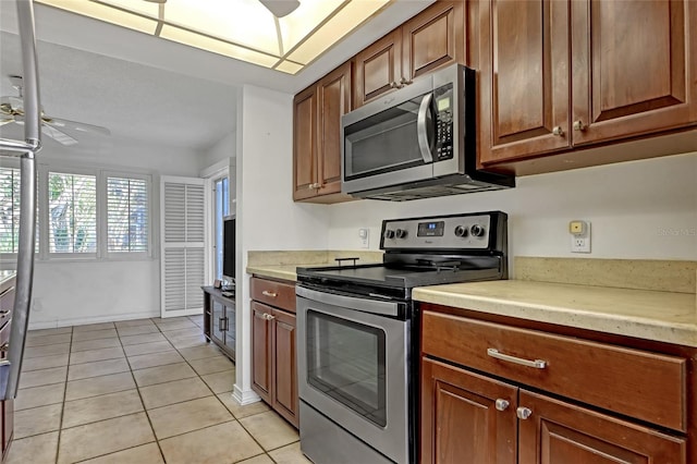 kitchen with ceiling fan, appliances with stainless steel finishes, and light tile patterned flooring