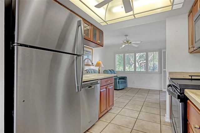 kitchen with ceiling fan, stainless steel appliances, and light tile patterned floors