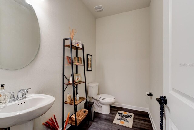 4009 Winding Meadows St, Apopka, FL 32712 - half bath featuring wood finished floors, toilet, a sink, baseboards, and visible vents