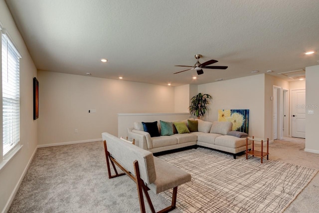 living room featuring a textured ceiling, light colored carpet, and ceiling fan