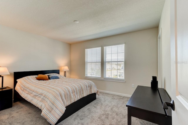 bedroom with a textured ceiling and light colored carpet