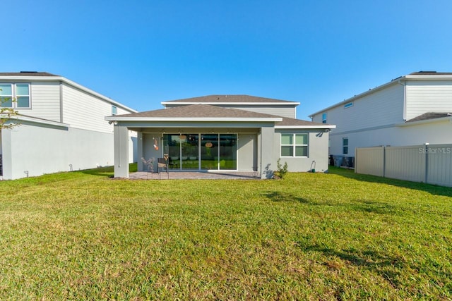 4009 Winding Meadows St, Apopka, FL 32712 - rear view of house featuring fence, roof with shingles, and a yard