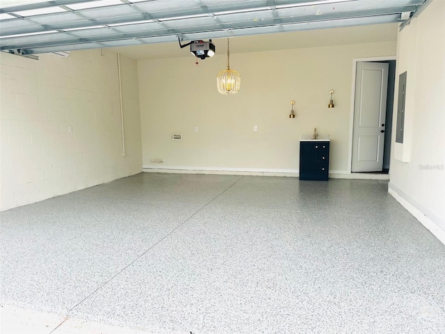 garage featuring concrete block wall, electric panel, and a garage door opener