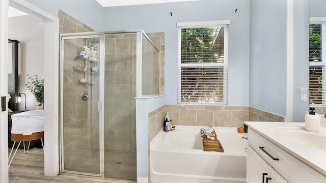 bathroom featuring vanity, hardwood / wood-style flooring, a wealth of natural light, and plus walk in shower