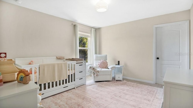 bedroom featuring light carpet and a crib