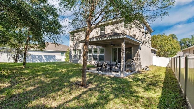 rear view of property with a yard, a patio area, and ceiling fan