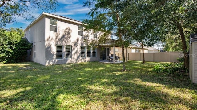 rear view of property with a yard and a patio area