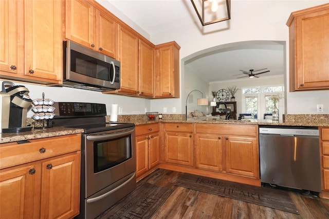 kitchen featuring dark wood-type flooring, sink, appliances with stainless steel finishes, light stone counters, and ceiling fan