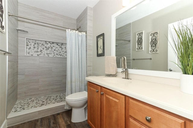 bathroom featuring vanity, toilet, hardwood / wood-style flooring, and walk in shower